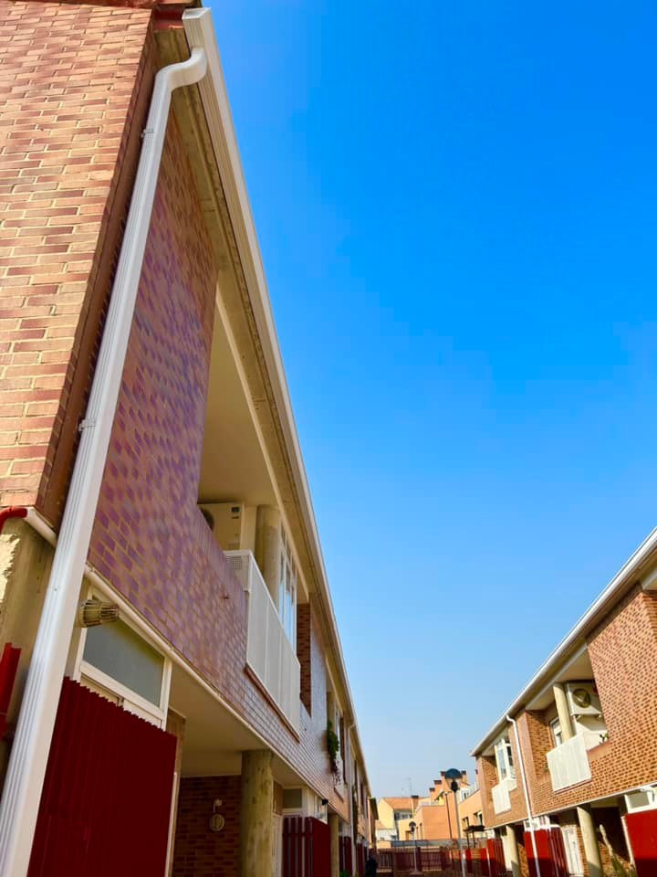 Vista de canalones de aluminio, bajante pluvial instalados en una urbanización